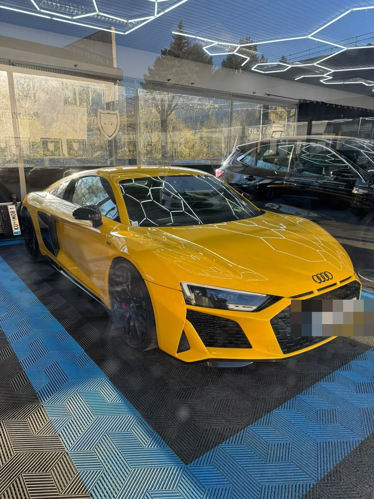 Audi R8 in der Halle von Saff Car Lounge in Kufstein nach der Aufbereitung, Hexagon-Leuchten spiegeln sich im Lack