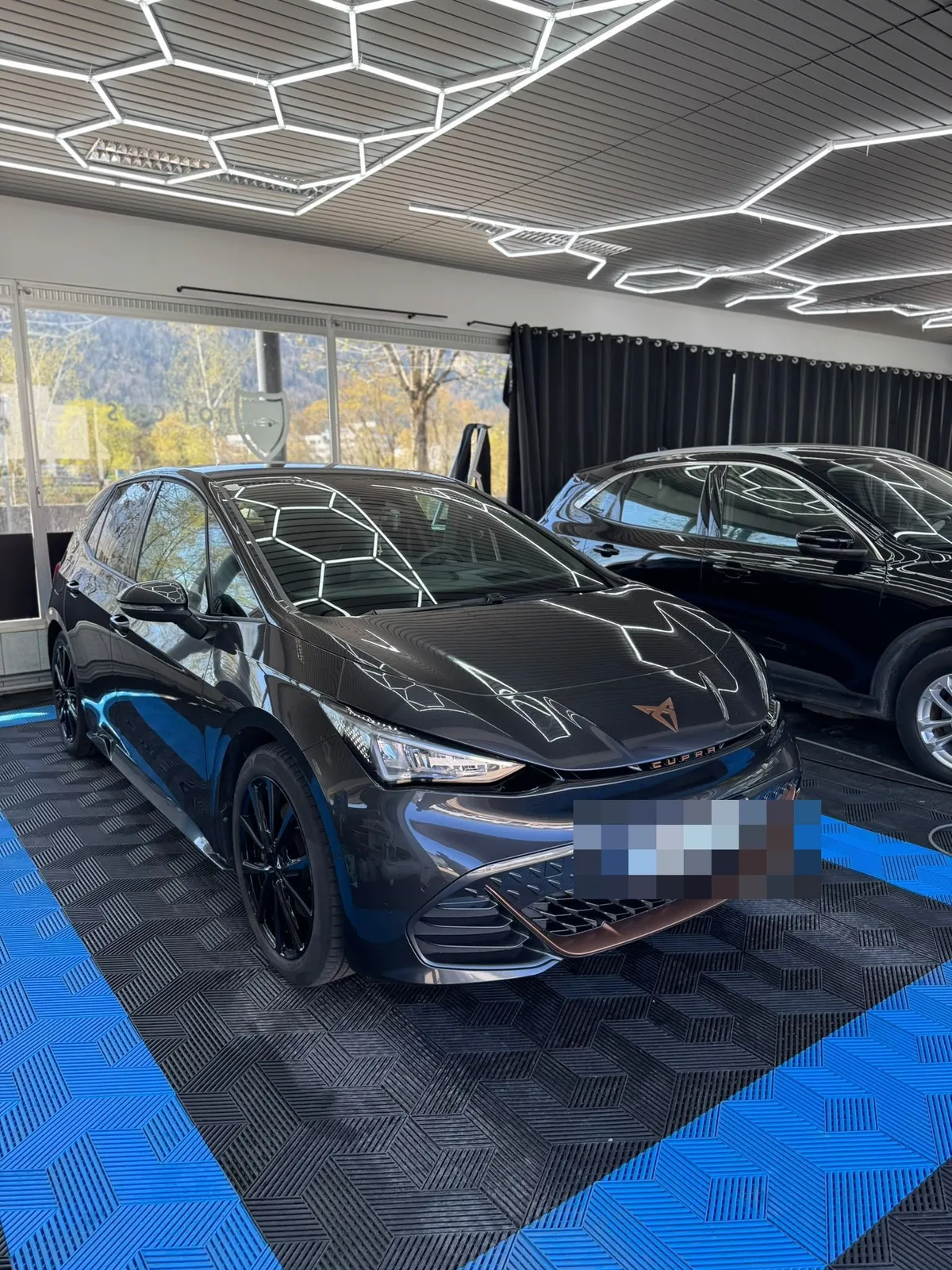 Cupra Formentor in der Halle von Saff Car Lounge in Kufstein nach der Aufbereitung, Hexagon-Leuchten spiegeln sich im Lack