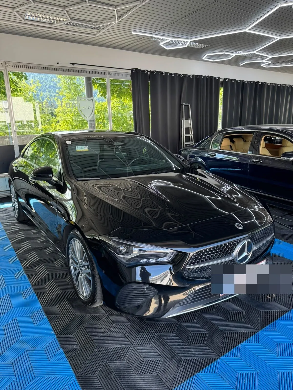 Mercedes CLA in der Halle von Saff Car Lounge in Kufstein nach der Aufbereitung, Hexagon-Leuchten spiegeln sich im Lack