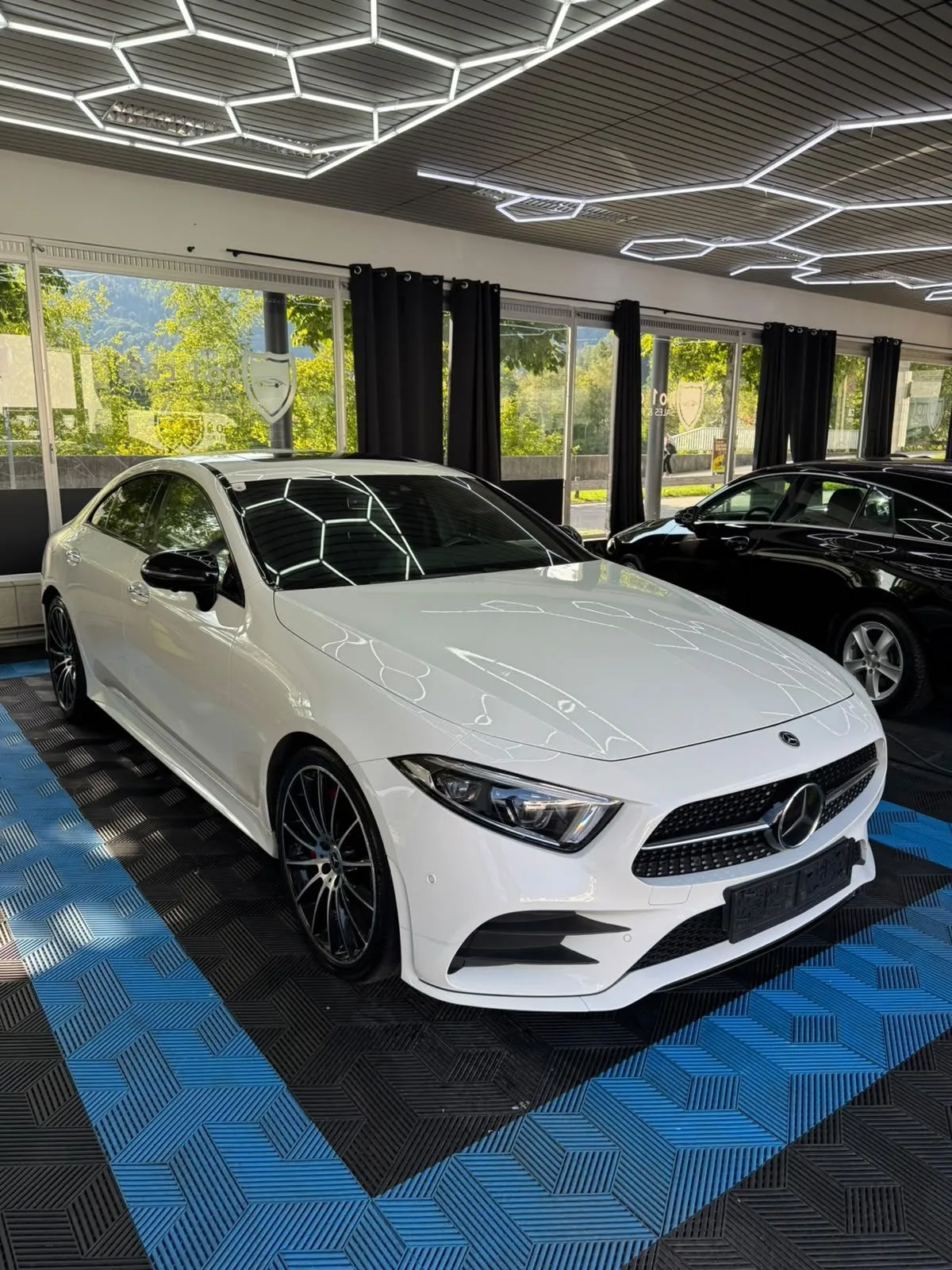 Mercedes CLS in der Halle von Saff Car Lounge in Kufstein nach der Aufbereitung, Hexagon-Leuchten spiegeln sich im Lack