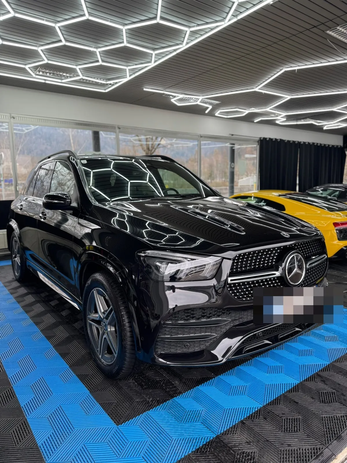 Halle mit Mercedes GLE, Fensterfront und Hexagon-Leuchten